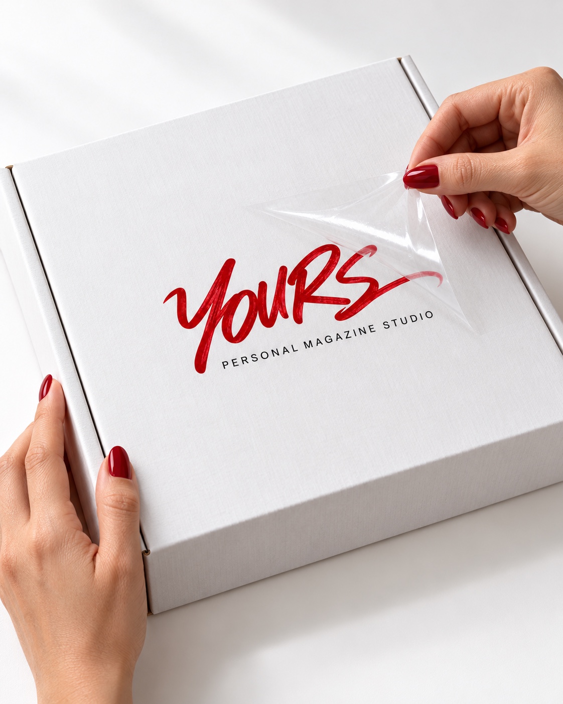 הדמיית ידיים עם לק אדום מניחות את לוגו YOURS על הקופסה הלבנה